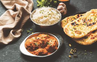 A delicious looking curry with rice and naan bread.