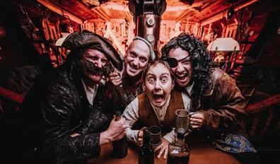 4 pirates drinking in the galley of a ship