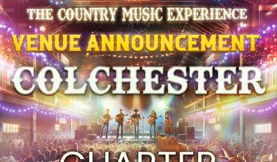 A brightly lit stage with the words: 'The Country Music Collective Presents The Country Music Experience Venue Announcement Colchester, Charter Hall'