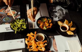 A selection of wagamama food laid out on the table.