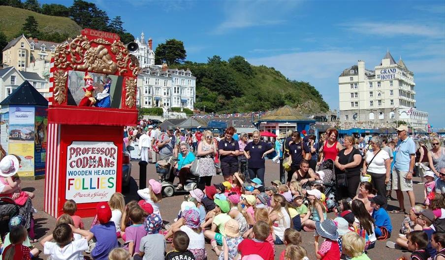 Plant a theuluoedd yn gwylio sioe Pwnsh a Judy yn Llandudno