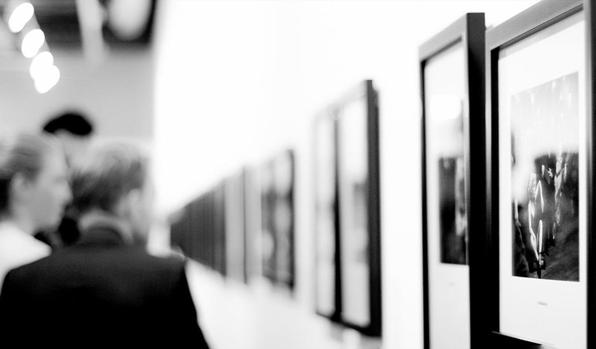 People looking at art on a wall