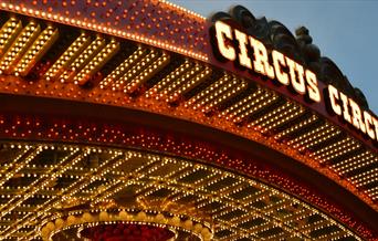 Circus roof sign surrounded by yellow and red lights