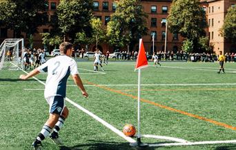 Man playing in a football match doing a corner kick