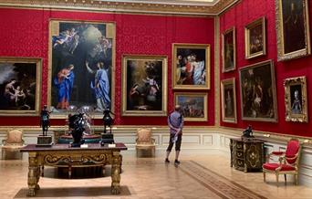 Man looking at painting in an opulent room