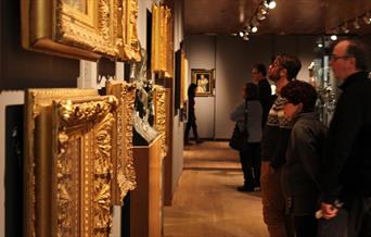 Patrons looking at art in gold frames