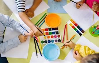 Children using pencils paint and colourful paint