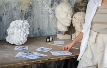 A selection of sketches and white sculptures on a table