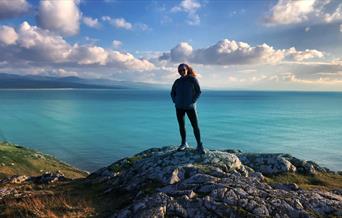 Sian Humpherson standing on mountain with sea in background