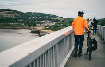 Beiciwr yn cerdded ar Bont Conwy