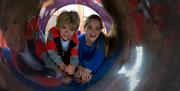 Children in play area tunnel at Penmaenmawr