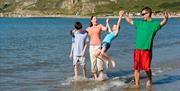 Family paddling on West Shore Beach