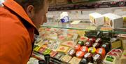 Man looking at the cheese selection at Blas ar Fwyd, Llanrwst