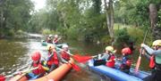 Groups of children and adults enjoying rafting on the river