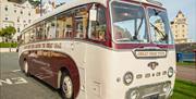 Marine Drive vintage tour bus with Grand Hotel in background