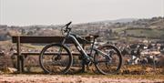 A bike resting against a bench with a view over the mountain in the background