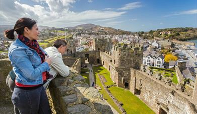 Pobl yn edrych i mewn i Gastell Conwy o'r tyredau