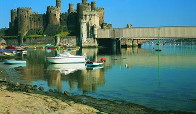 Conwy Castle with Conwy railway bridge to the right of the image and Conwy estuary in the foreground