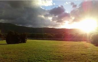 Image of field with views of the mountains at sunset