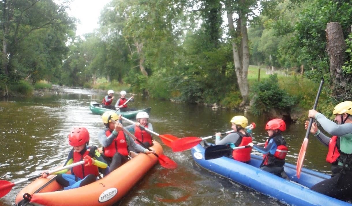 Groups of children and adults enjoying rafting on the river