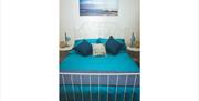 bedroom image of  white iron double bed with blue bedding.