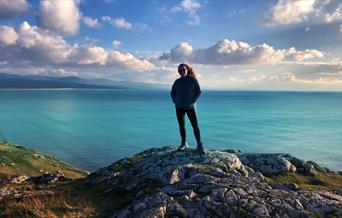 Sian Humpherson standing on mountain with sea in background