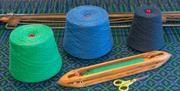 Image of green, blue and grey wool next to tools.