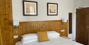 Double bed with wooden panelling headboard.