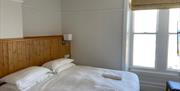 Double room with wood panelling headboard and white linen