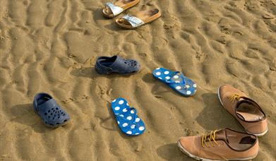 Assortment of shoes on beach
