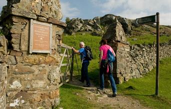 Two walkers at the gateway entry to Pensychnant Nature Reserve