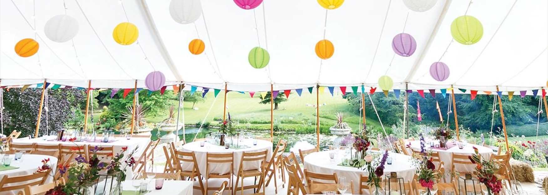 Event marquee with coloured hanging lanterns at Cowley Manor