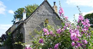 View of The Trout Inn from the outside. Flowers are at the front of the image.