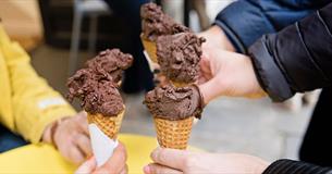 Three people holding chocolate gelato cones
