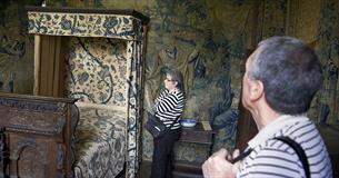 Visitors looking at textiles in the Fettiplace Room at Chastleton