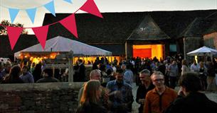 beer and bunting at the Cogges barn in the evening with crowds