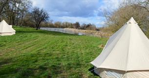 Two bell tents with the river in the background