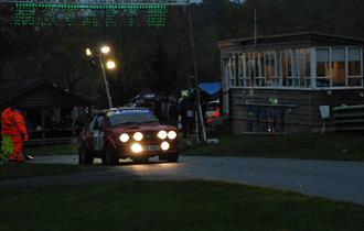 An iconic Ford Escort rally car takes to the hill at dusk in 2022