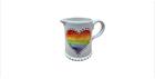 A mug that has a rainbow coloured heart on it