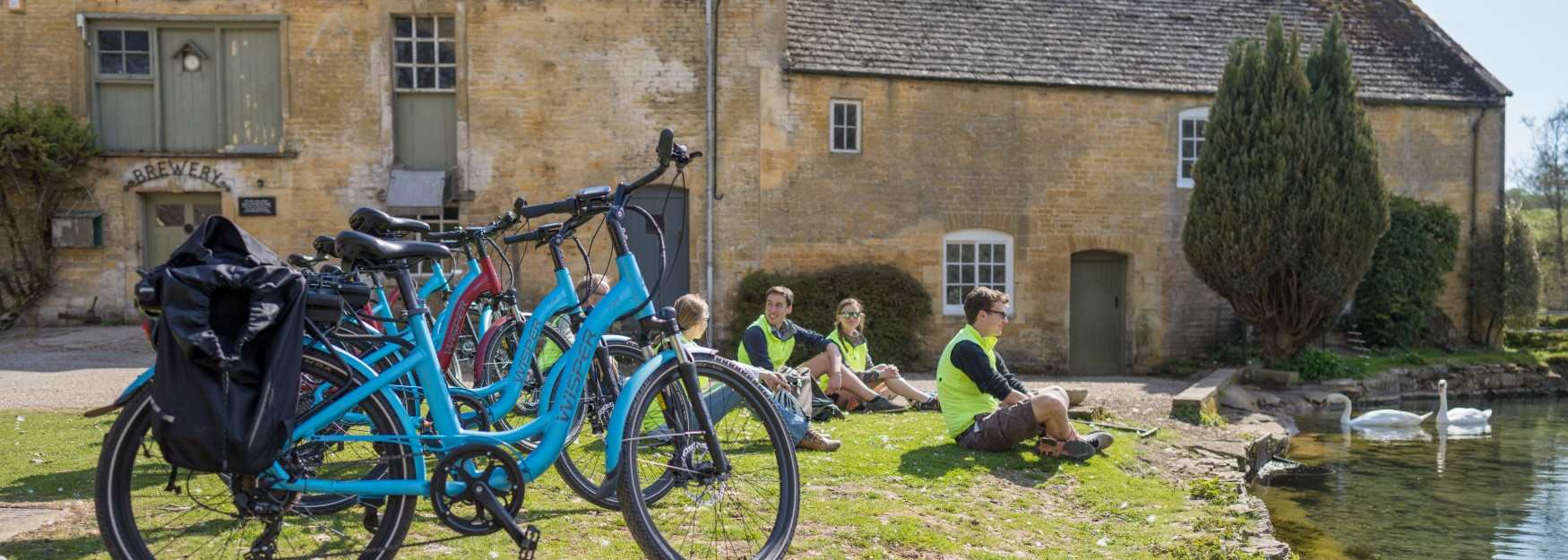 Group of cyclists resting by a river