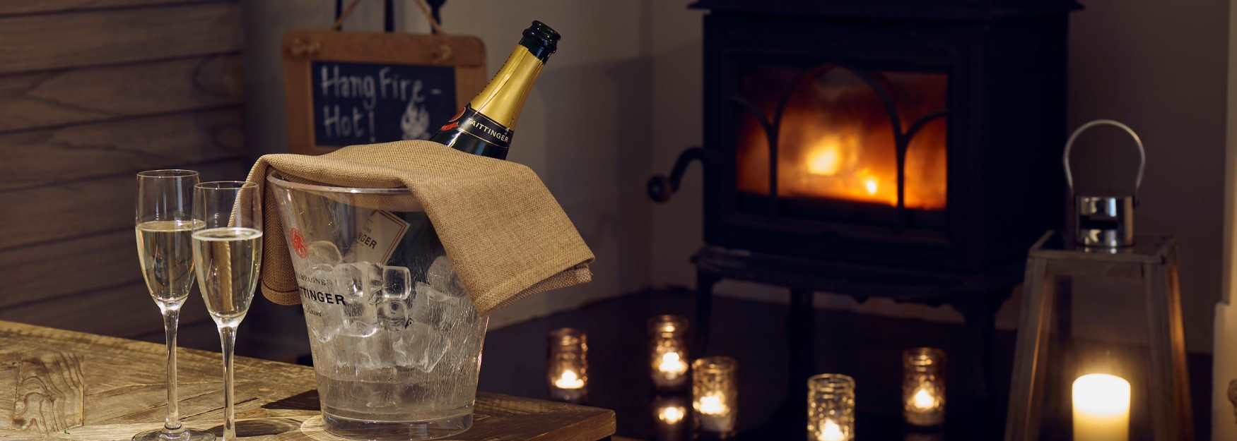 Champagne and candles in front of a log fire at The Painswick
