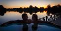 Couple in an outdoor hot tub at Log House Holidays