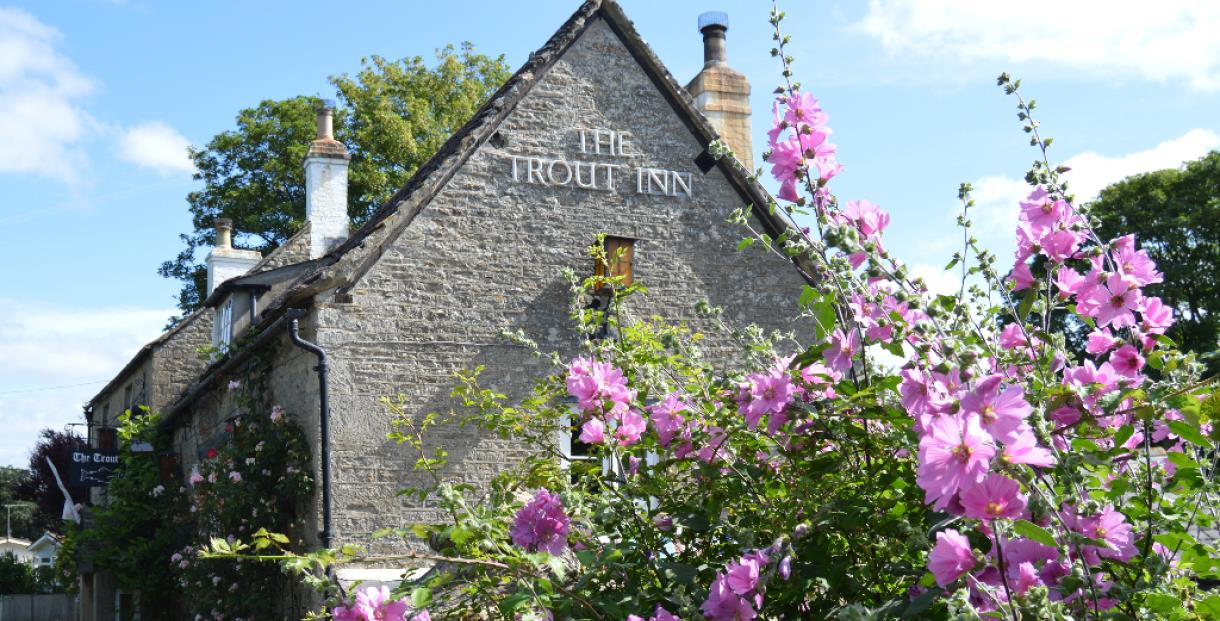 View of The Trout Inn from the outside. Flowers are at the front of the image.