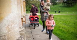 A family with a pushchair and Easter eggs outside the house at Dyrham Park 