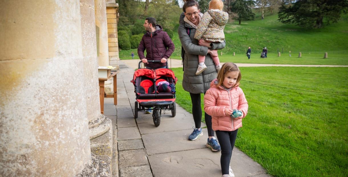A family with a pushchair and Easter eggs outside the house at Dyrham Park