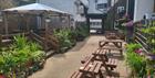 Outdoor seating area with wooden benches and potted plants