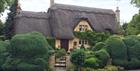 A beautiful traditional thatched cottage, which you can see on a Go Cotswolds guided tour of the Cotswolds