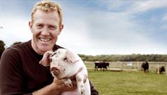 Adam Henson with a piglet at Cotswold Farm Park