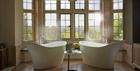Twin bath tubs with views across the grounds in the Oak suite at Foxhill Manor