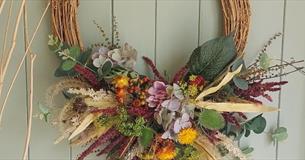 Willow frame wreath adorned with seasonal foliage and dried flowers